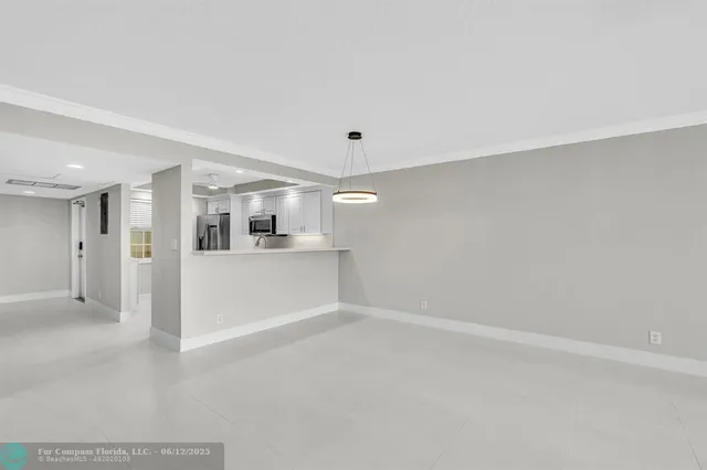 a view of a livingroom with wooden floor and kitchen