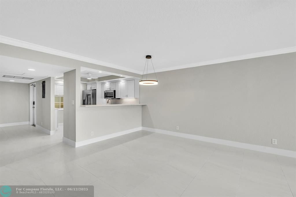 3800 Oaks Clubhouse Drive, Unit 201 Pompano Beach, FL 33069 - Photo 22 of 29 a view of a livingroom with wooden floor and kitchen