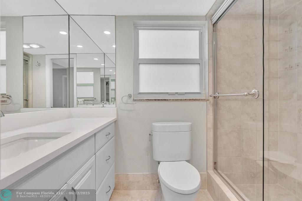3800 Oaks Clubhouse Drive, Unit 201 Pompano Beach, FL 33069 - Photo 4 of 29 a spacious bathroom with a granite countertop sink toilet a mirror and a shower