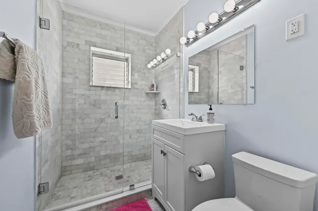 a bathroom with a sink a toilet and shower