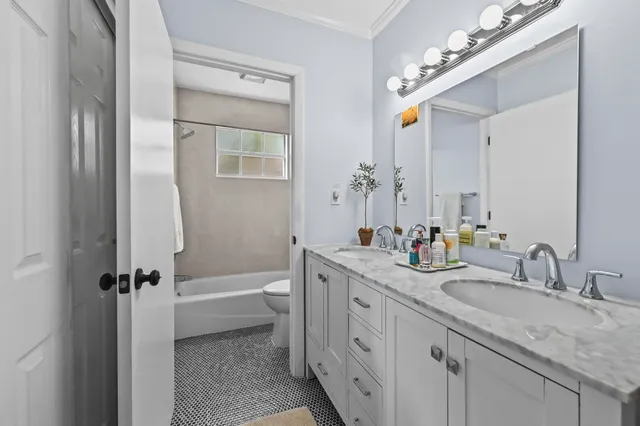 a bathroom with a granite countertop sink mirror toilet and bathtub
