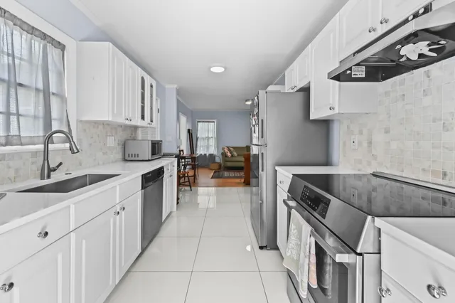 a kitchen with stainless steel appliances sink stove microwave and cabinets
