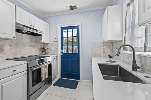 a kitchen with stainless steel appliances a sink stove and cabinets