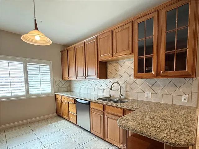 a kitchen with stainless steel appliances granite countertop a sink and a window