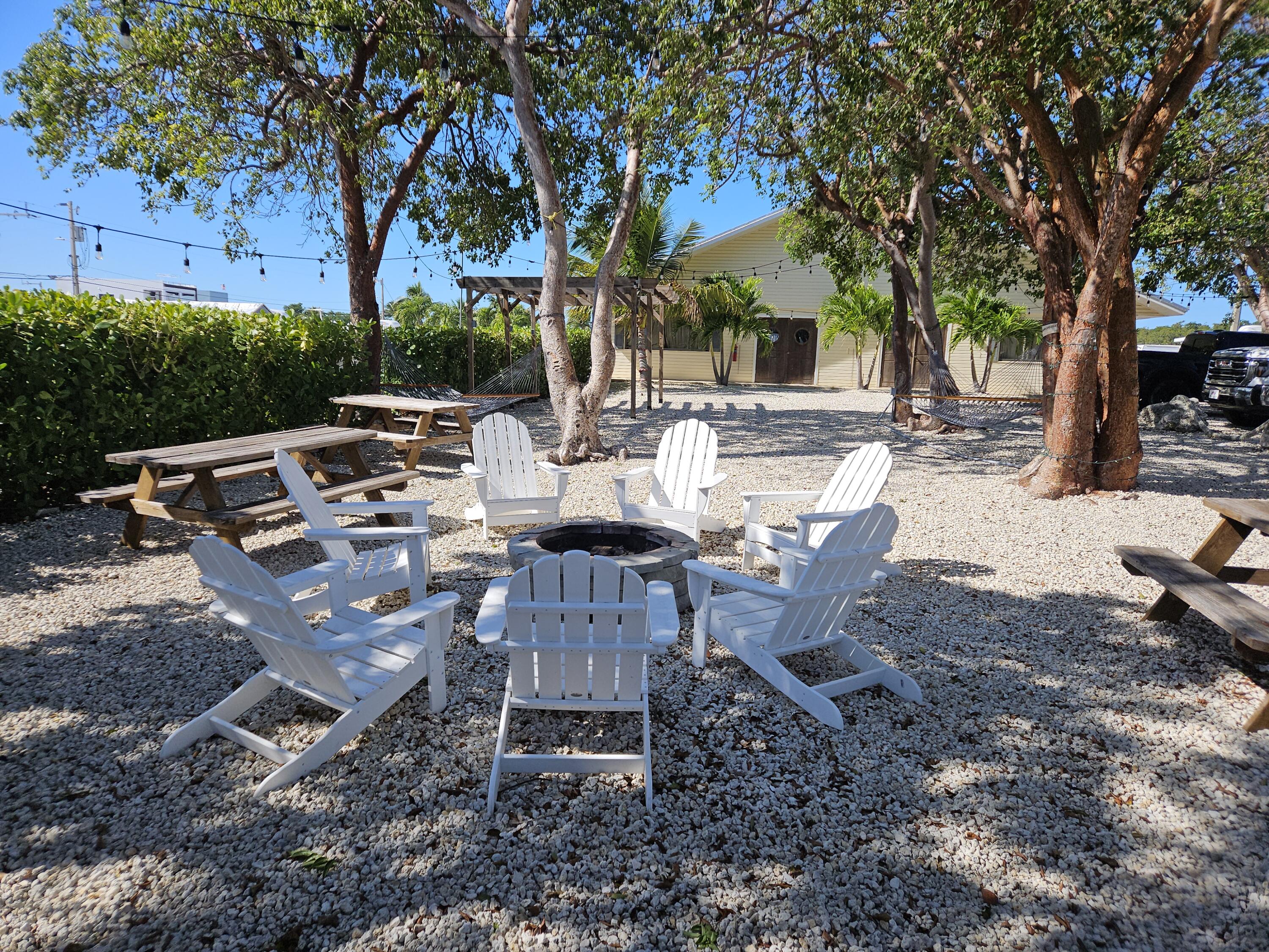 325 Calusa Street, Unit 245 Key Largo, FL 33037 - Photo 34 of 48 a view of a backyard with table and chairs and a fire pit