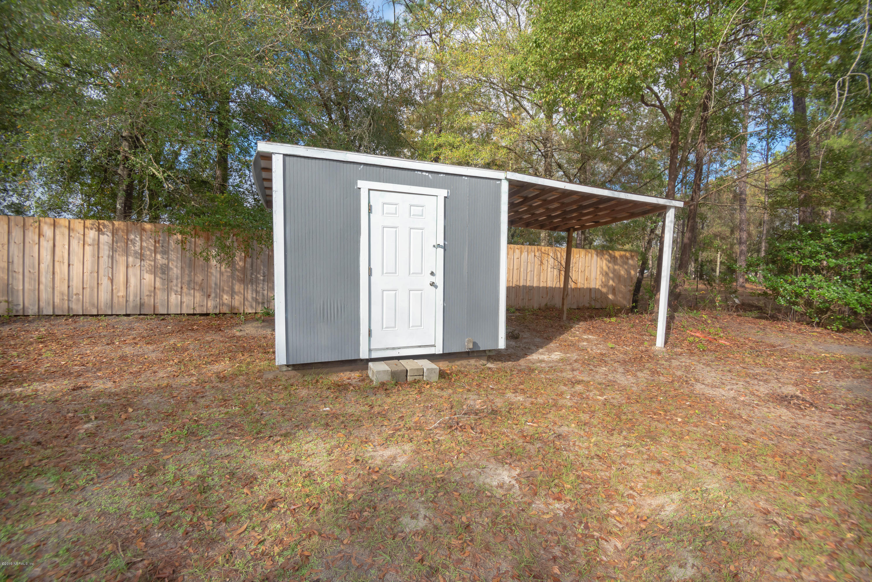 9964 River Oak Circle Glen St. Mary, FL 32040 - Photo 33 of 41 a view of backyard with large trees and wooden fence