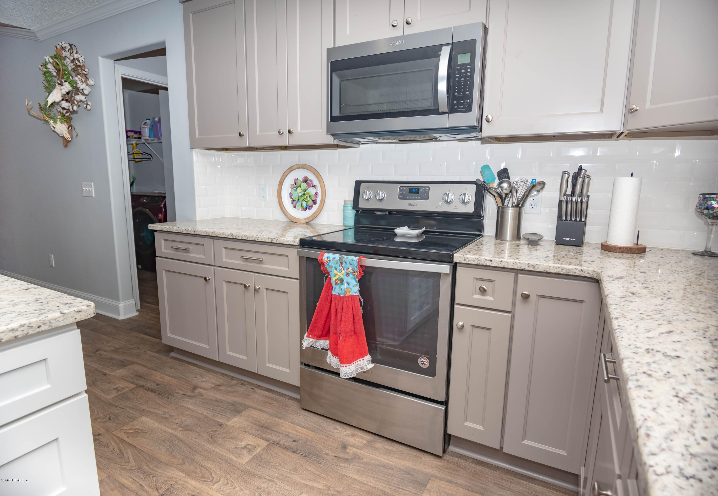 9964 River Oak Circle Glen St. Mary, FL 32040 - Photo 10 of 41 a kitchen with stainless steel appliances granite countertop a stove top oven microwave and cabinets