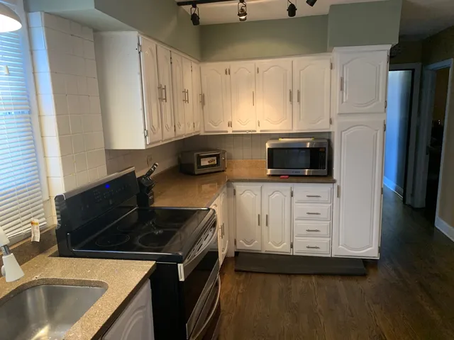 a kitchen with white cabinets and black appliances