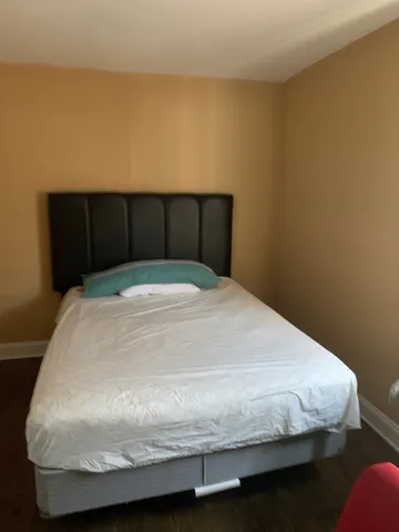 a bed sitting in a bedroom with wooden floor