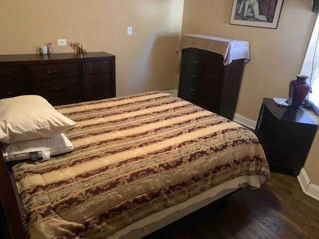 a bed sitting in a bedroom and dresser