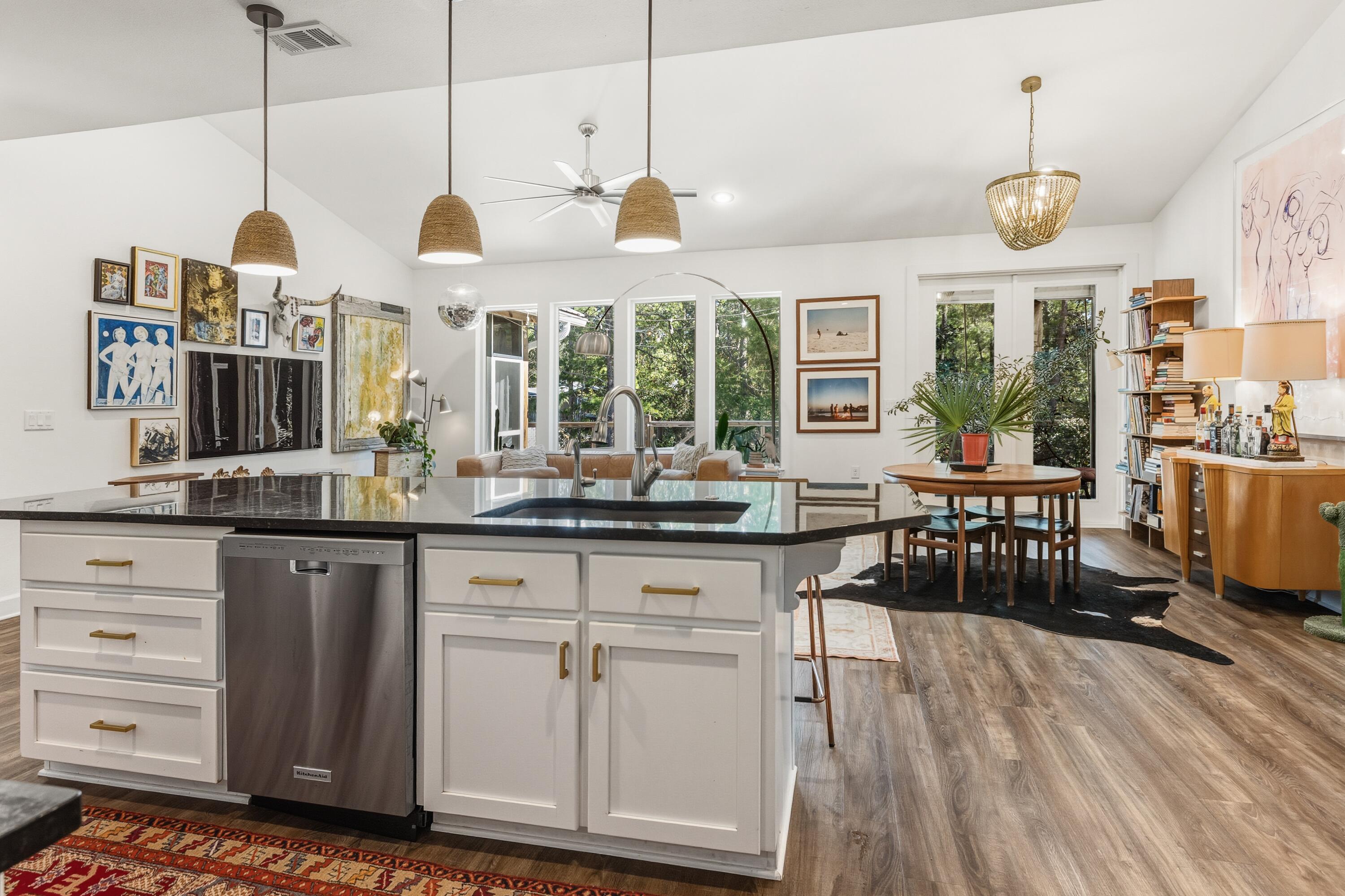 448 Ricker Avenue Santa Rosa Beach, FL 32459 - Photo 9 of 30 a open kitchen with stainless steel appliances granite countertop a stove and white cabinets with wooden floor