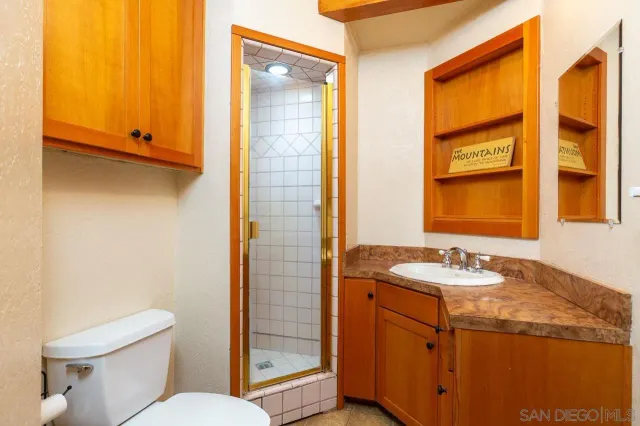 a bathroom with a granite countertop sink toilet and shower