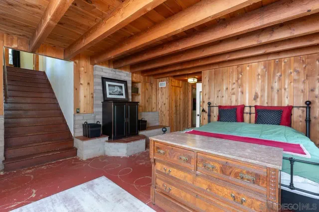 a bedroom with a bed and a dresser next to a window