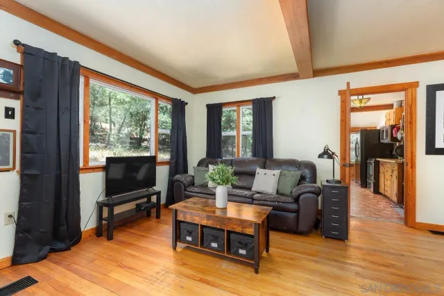 a living room with furniture a flat screen tv and a floor to ceiling window
