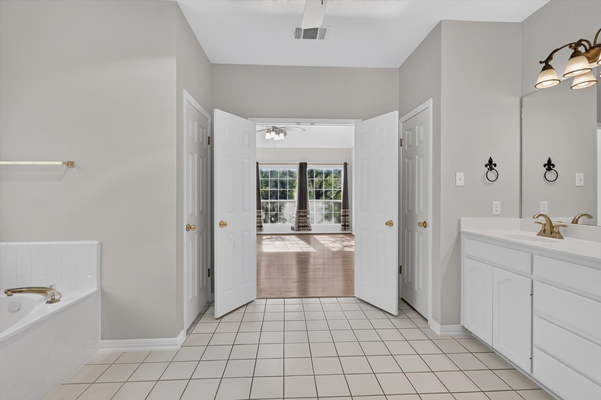 13615 Copperleaf Trail Manchaca, TX 78652 - Photo 21 of 38 A well-appointed bath boasts dual vanities and a relaxing soaking tub.
