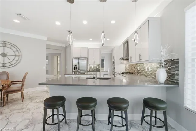 a kitchen with sink and view of living room