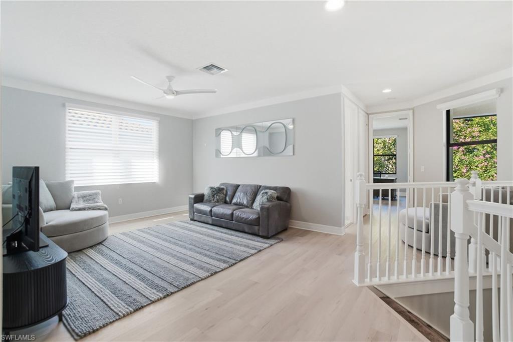 4654 Kensington Circle Naples, FL 34119 - Photo 14 of 48 a bedroom with furniture wooden floor and window