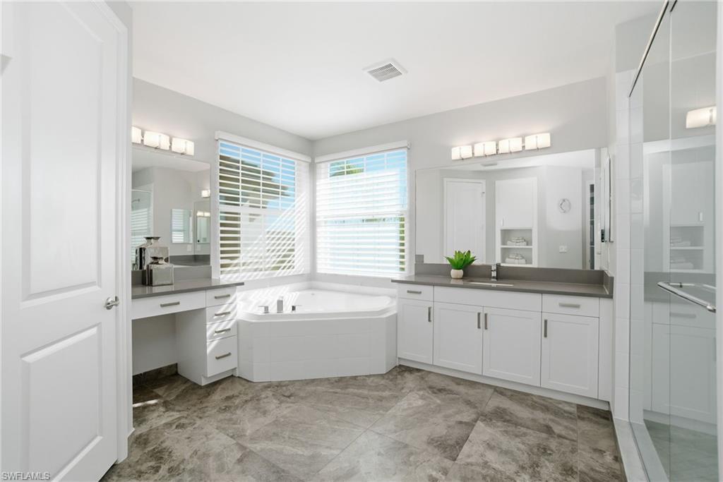4654 Kensington Circle Naples, FL 34119 - Photo 18 of 48 a bathroom with a tub sink and mirror