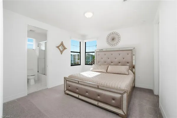 a bedroom with a bed and a refrigerator