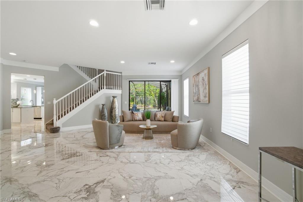 4654 Kensington Circle Naples, FL 34119 - Photo 2 of 48 a very nice looking living room with a large window and potted plants
