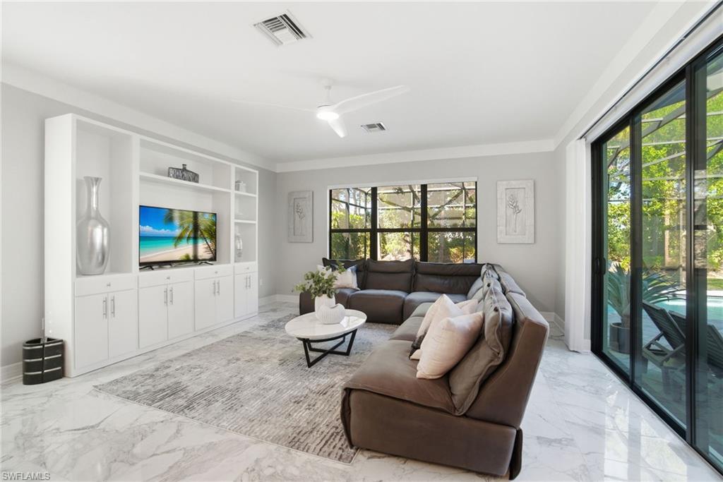 4654 Kensington Circle Naples, FL 34119 - Photo 3 of 48 a living room with furniture and a flat screen tv