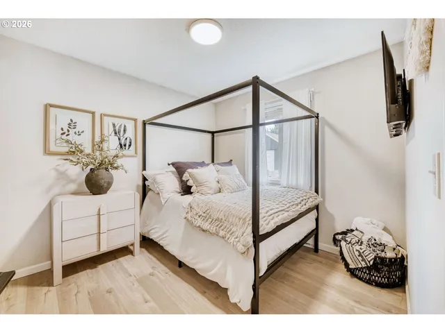 a bedroom with a bed and a painting on the wall