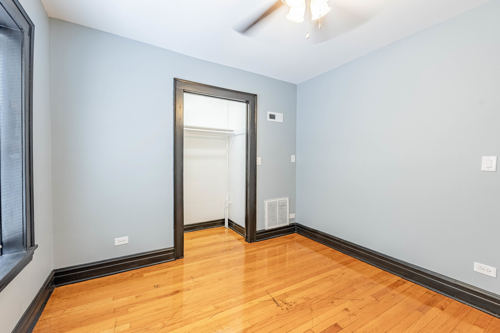 5805 South Whipple Street, Unit 1 Chicago, IL 60629 - Photo 5 of 15 an empty room with wooden floor and windows