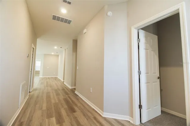 a view of a hallway with wooden floor and closet