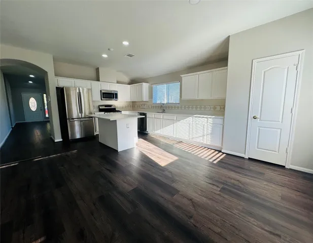 a kitchen with a refrigerator and a stove top oven