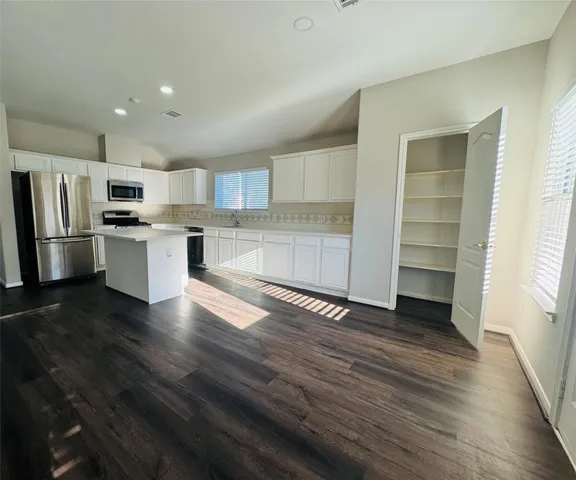 a kitchen with a refrigerator and a stove top oven