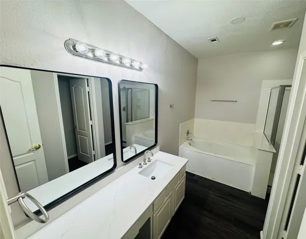 a bathroom with a tub sink and mirror
