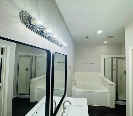 a view of an empty room with wooden floor and stairs