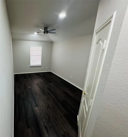 en empty room with wooden floor and windows