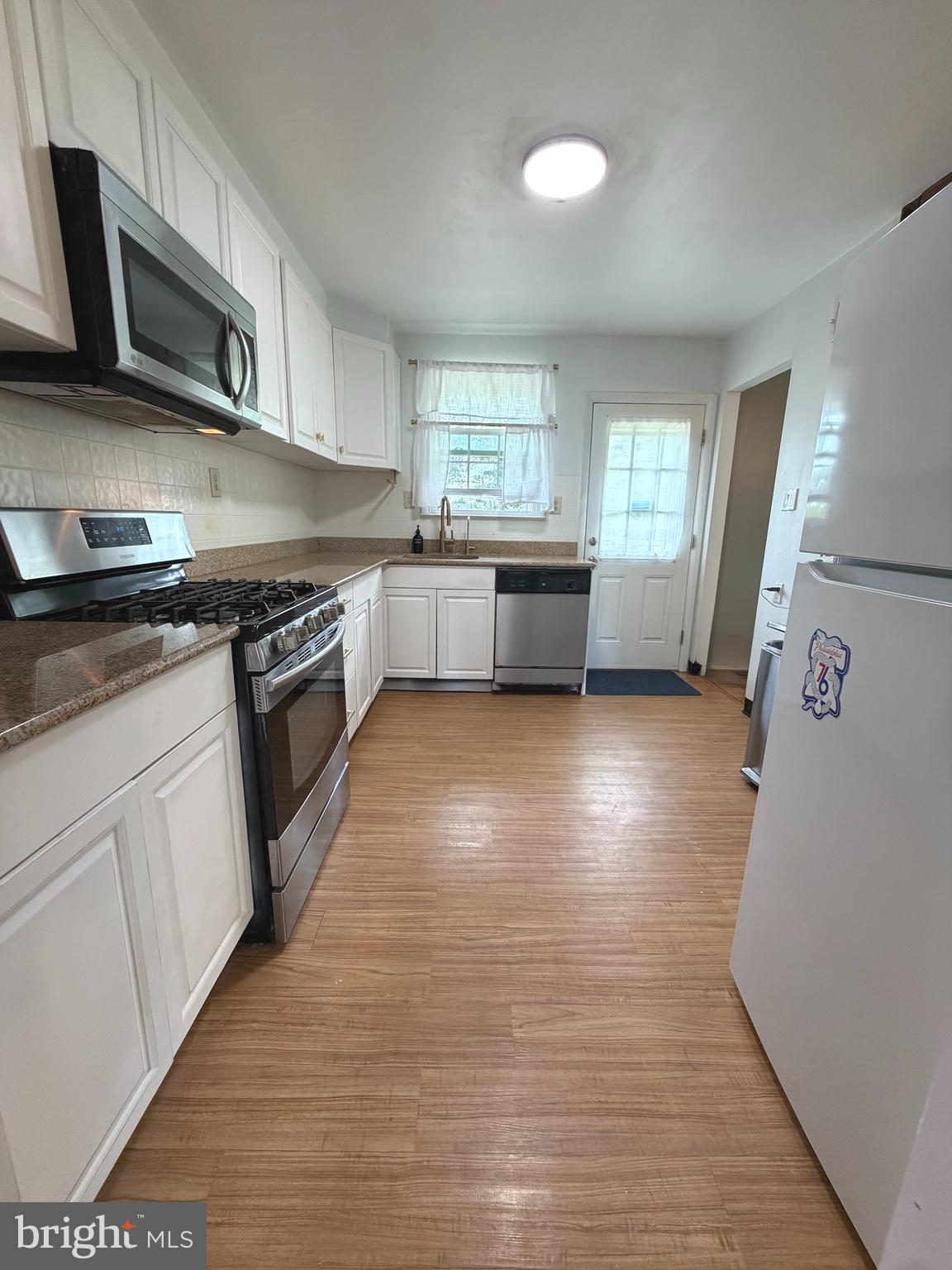 1207 Greenhill Road Flourtown, PA 19031 - Photo 3 of 9 a kitchen with stainless steel appliances granite countertop a stove a sink and a microwave