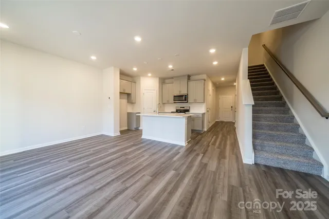 a view of kitchen with cabinets stainless steel appliances and wooden floor