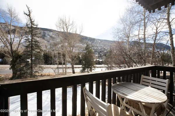 a view of a balcony with wooden floor and outdoor seating