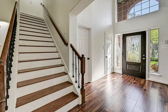 a view of a hallway with wooden floor and staircase
