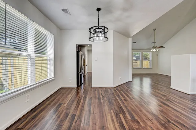 a view of a room with wooden floor exposed radiator and windows