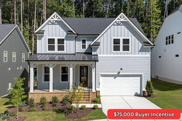 a view of a white house with large windows and a yard