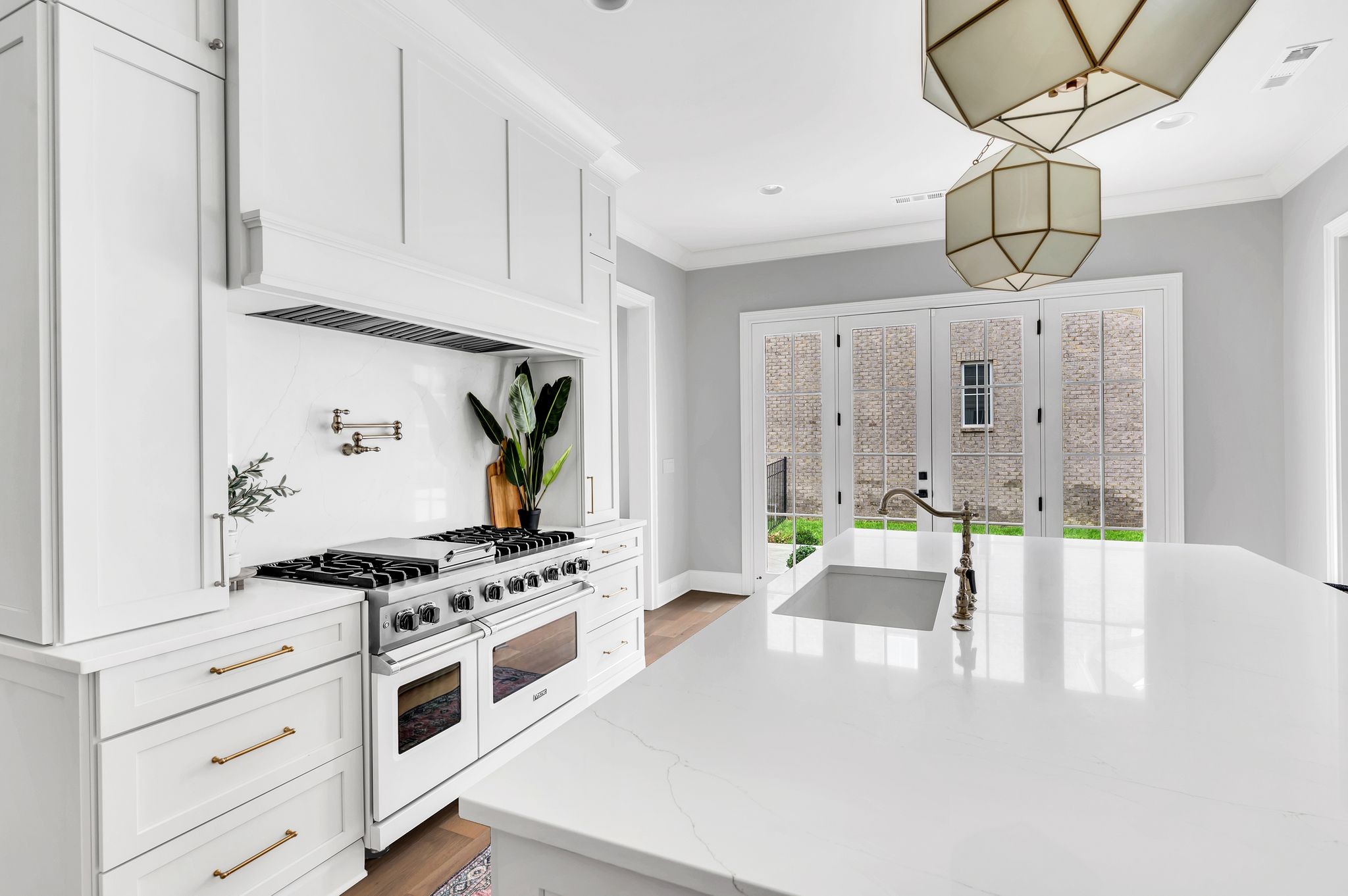 6081 Pasquo Road Nashville, TN 37221 - Photo 25 of 70 a white kitchen with stainless steel appliances granite countertop a stove and a wooden floors