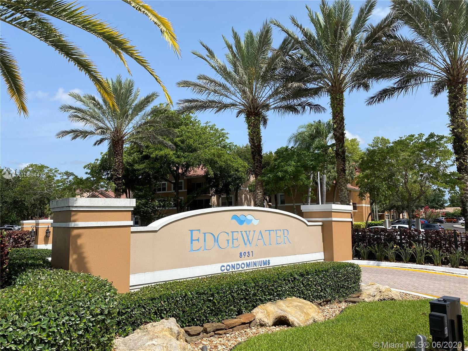 8741 Wiles Road, Unit 204 Coral Springs, FL 33067 - Photo 14 of 22 a front view of a house with a yard and garage