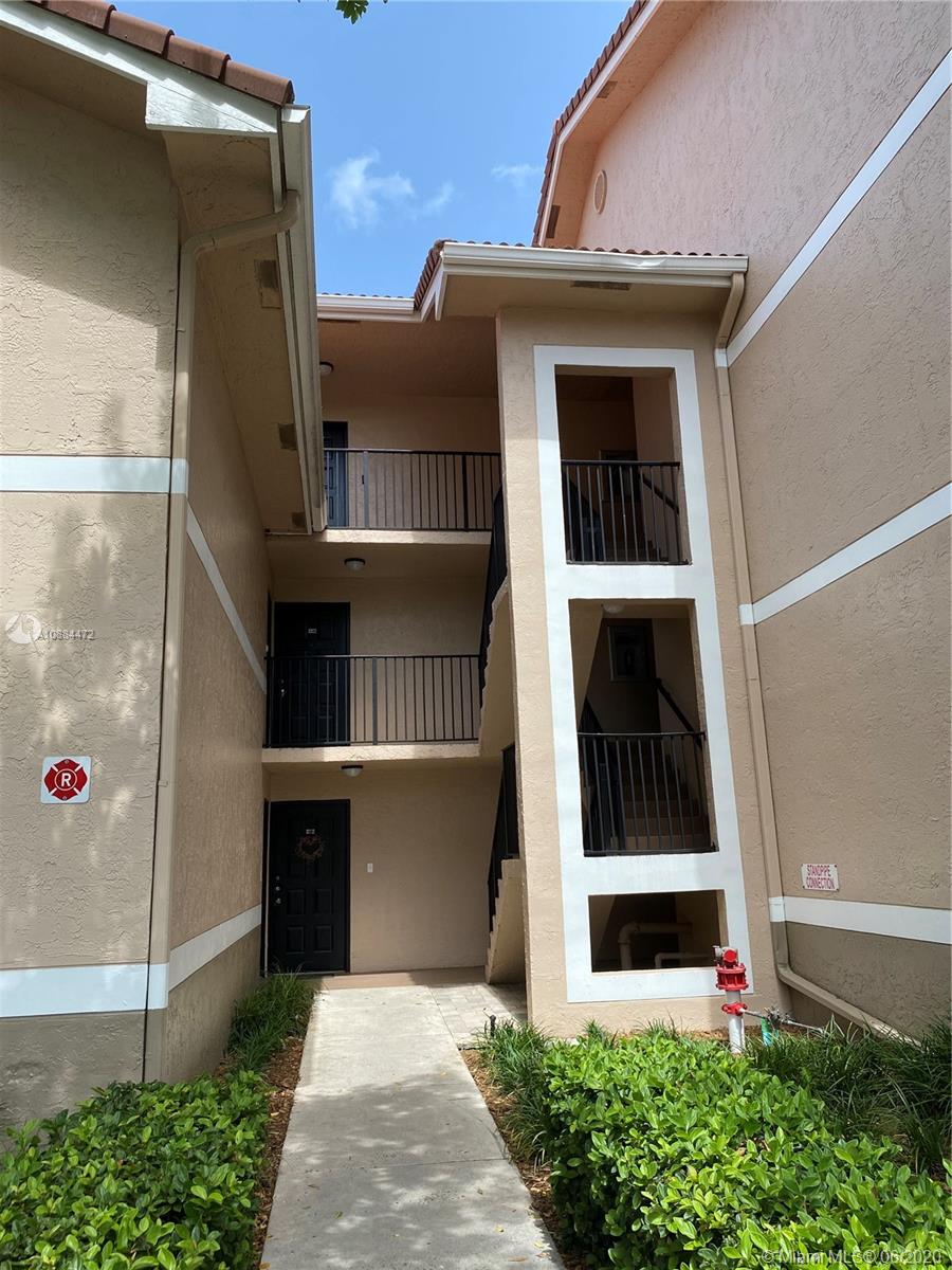 8741 Wiles Road, Unit 204 Coral Springs, FL 33067 - Photo 20 of 22 a front view of a house with a small garden