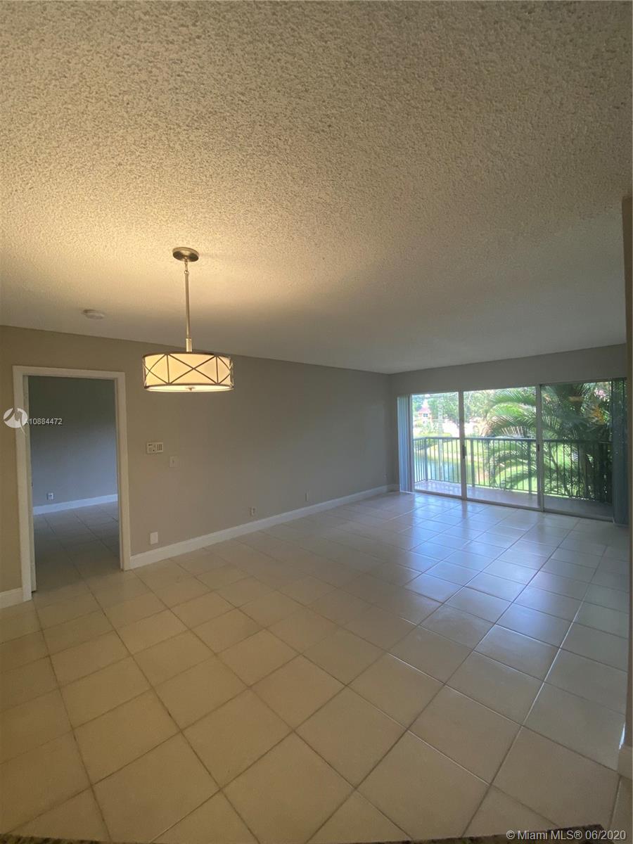 8741 Wiles Road, Unit 204 Coral Springs, FL 33067 - Photo 3 of 22 an empty room with windows and chandelier