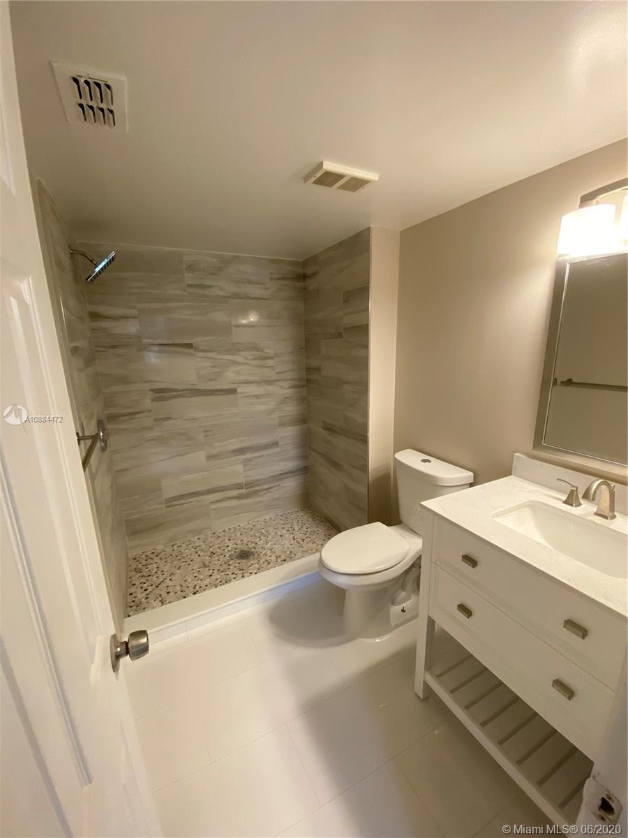 8741 Wiles Road, Unit 204 Coral Springs, FL 33067 - Photo 4 of 22 a bathroom with a sink a toilet and shower
