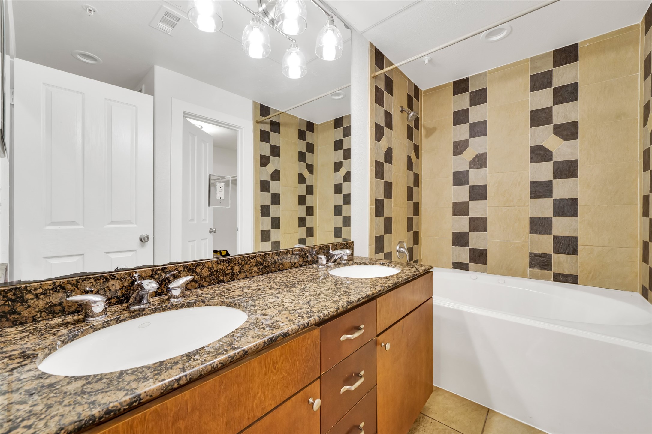 2216 Chenevert Street, Unit 6 Houston, TX 77003 - Photo 12 of 29 a bathroom with a granite countertop sink a mirror a bathtub and shower
