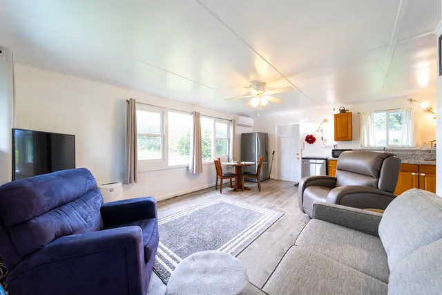 a living room with furniture a large window and a flat screen tv