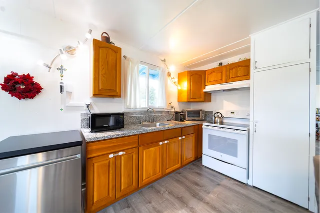 a kitchen with stainless steel appliances granite countertop a sink and a refrigerator