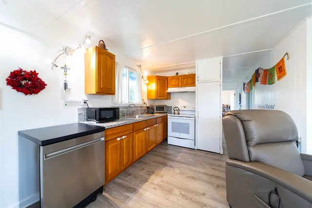 a kitchen with stainless steel appliances granite countertop a sink and a refrigerator