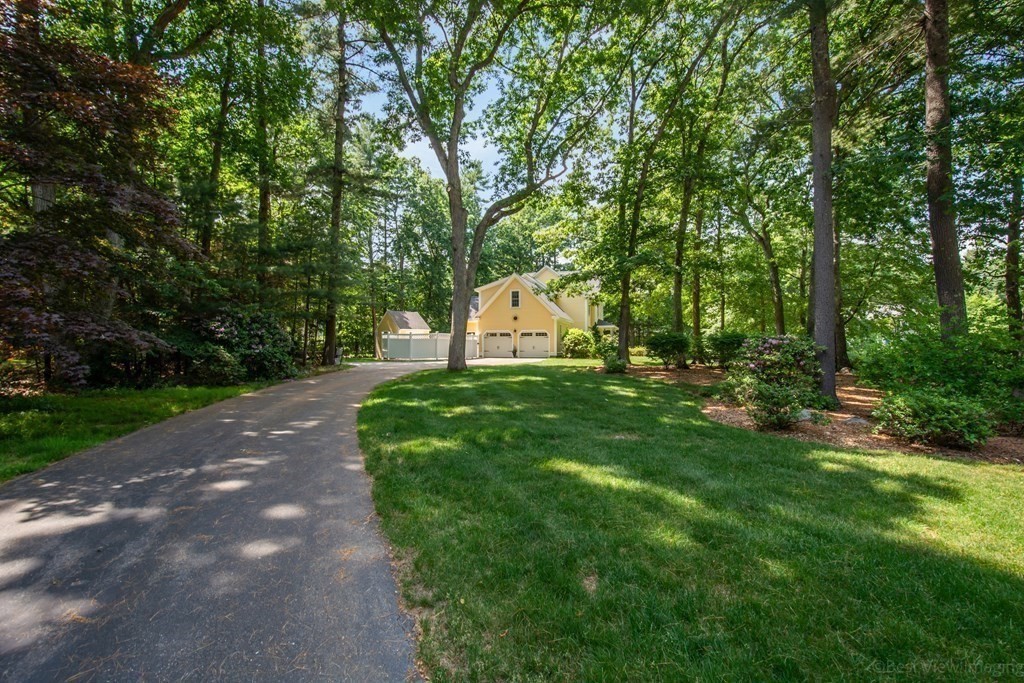 61 Coolidge Farm Road Boxborough, MA 01719 - Photo 36 of 39 a view of a white house with a big yard and large trees