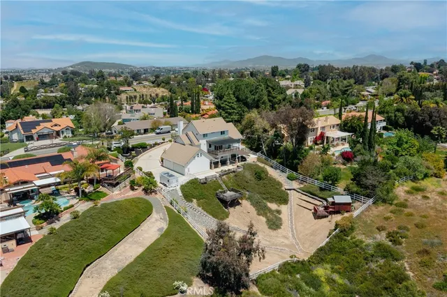an aerial view of residential houses with outdoor space and trees
